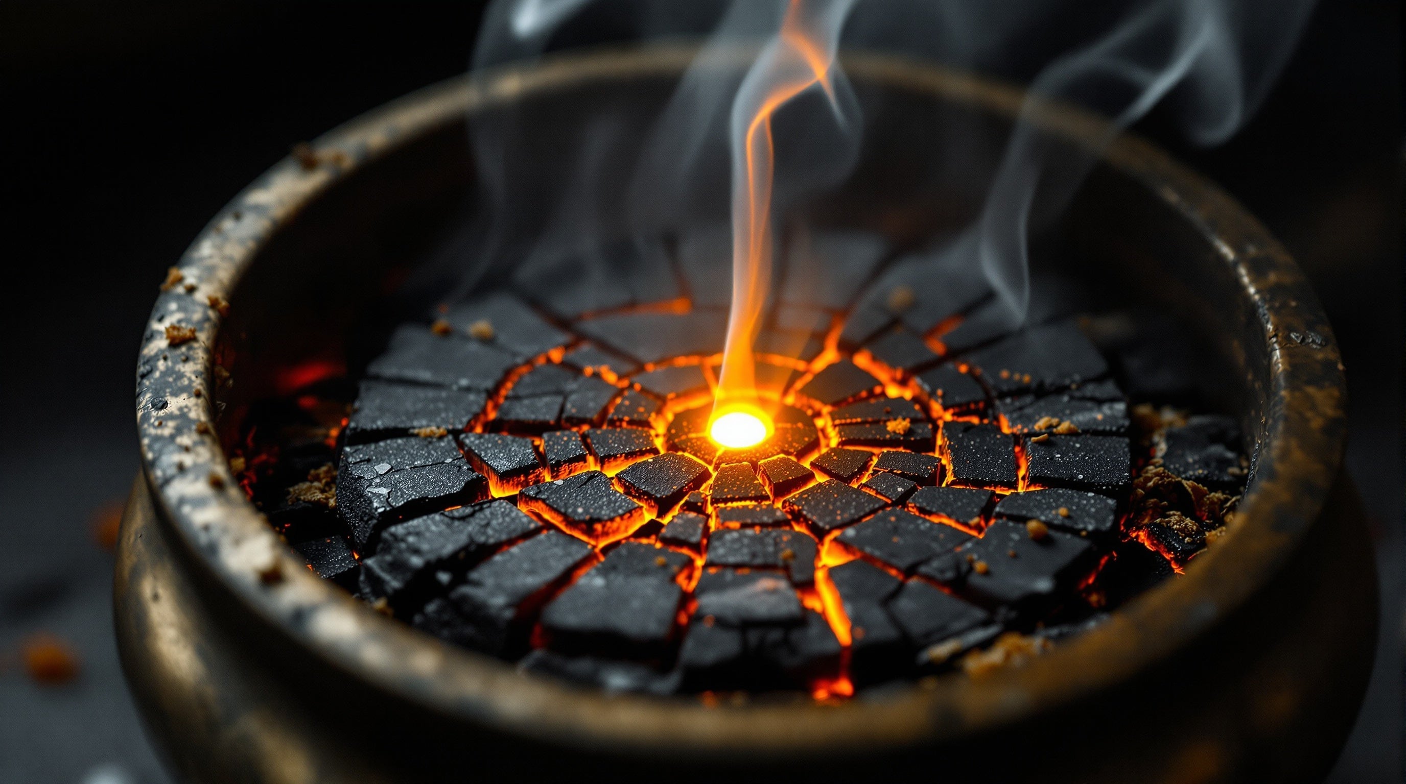 Macro of glowing charcoal and curling incense smoke in a brass censer against near-black — the best niche incense fragrances.