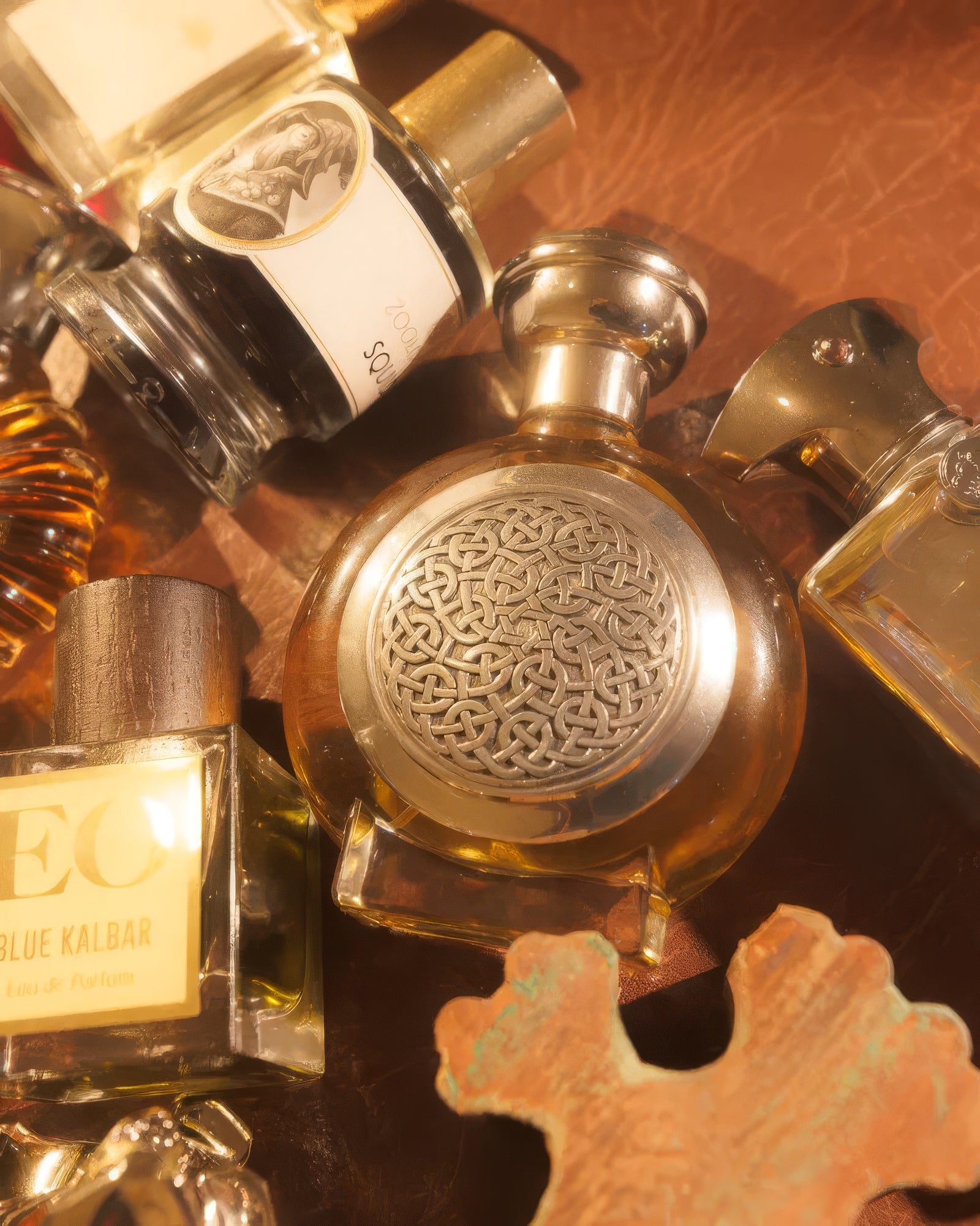 Boadicea the Victorious Bodacious frasco entre perfumes nicho sobre couro quente, decant de fragrância gourmand