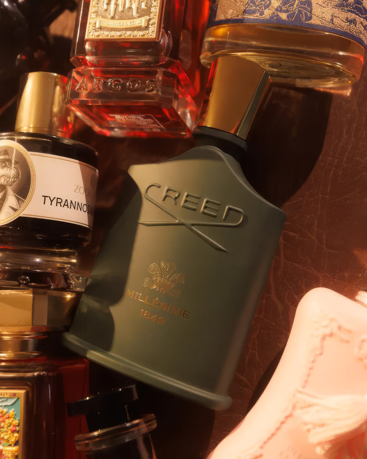 Creed Millesime 1849 レザーの上で香水瓶に囲まれたフラコン、ウッディなニッチフレグランスのデカント