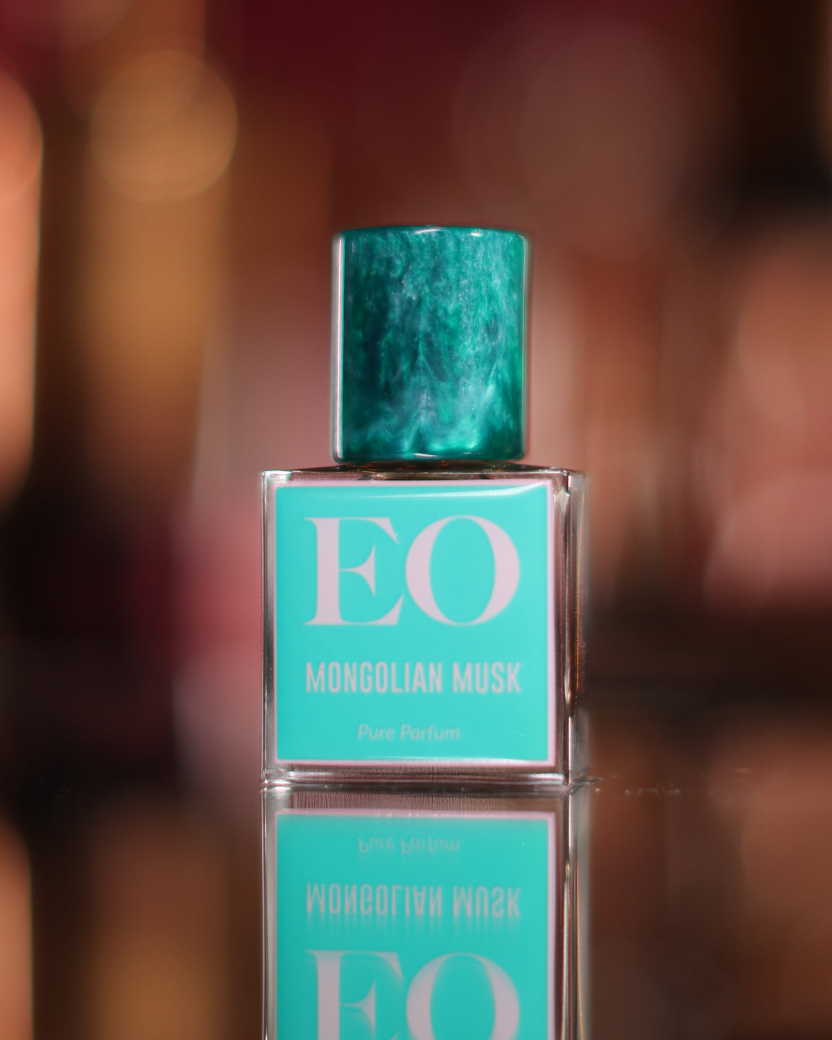 Ensar Oud Mongolian Musk square bottle with marbled teal cap and turquoise EO label reflected in a dark mirror, musky extrait de parfum decant