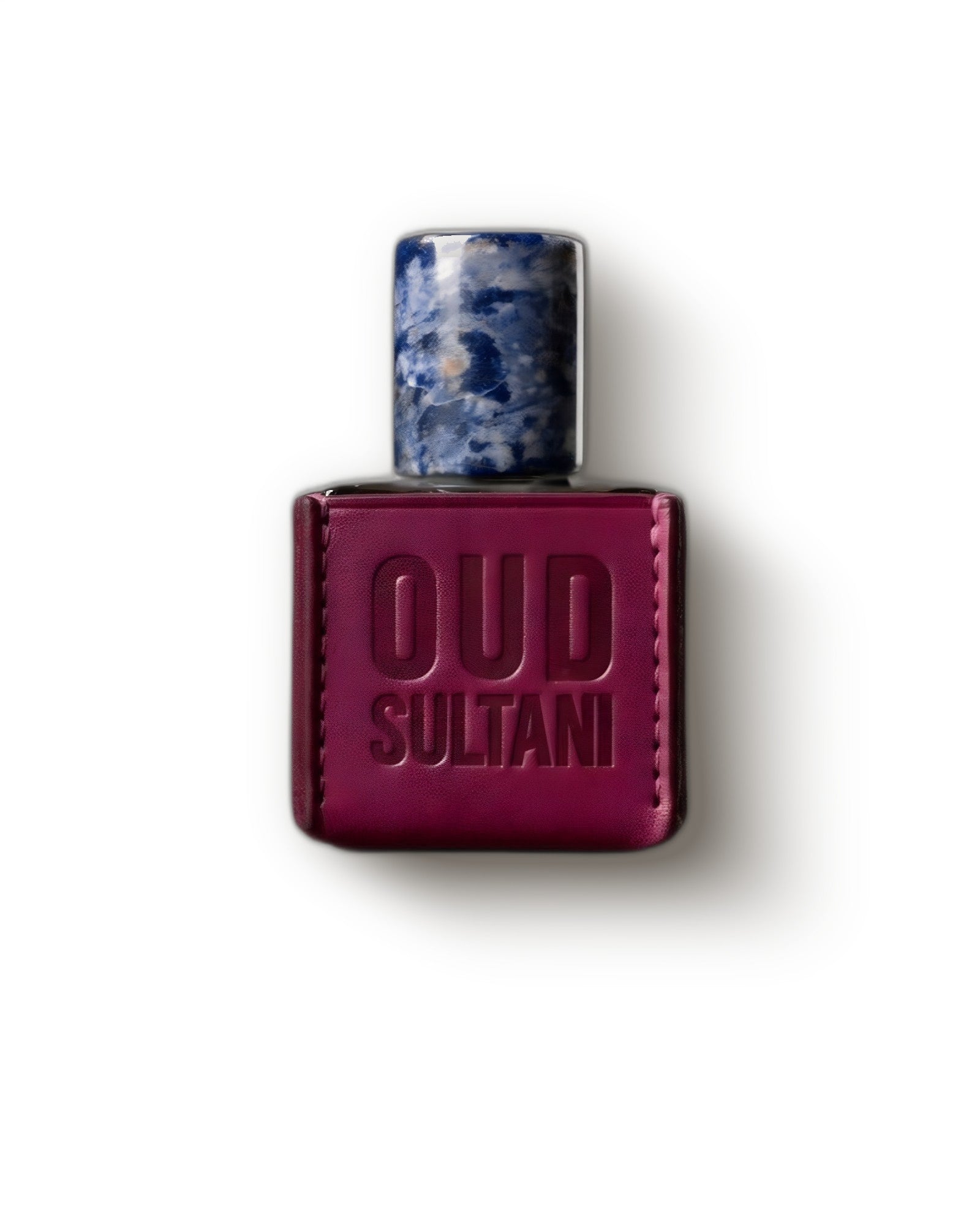 Ensar Oud Oud Sultani Kannan Koh magenta leather-clad bottle with blue stone cap on cream, oud extrait de parfum decant