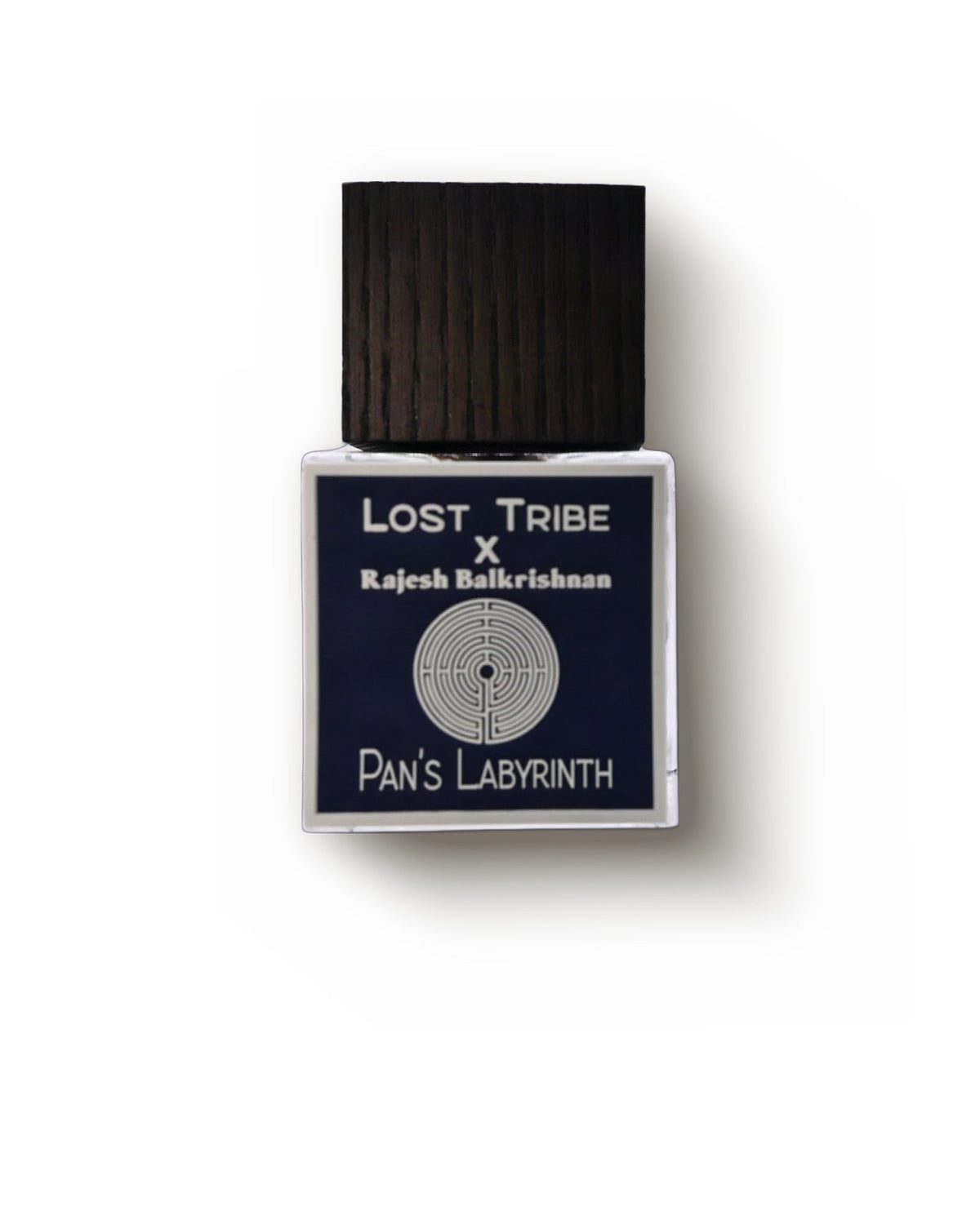 Lost Tribe Pan's Labyrinth v2, front view: a square bottle under a dark ribbed wooden cap, its navy label reading Lost Tribe x Rajesh Balkrishnan above a labyrinth emblem and Pan's Labyrinth.