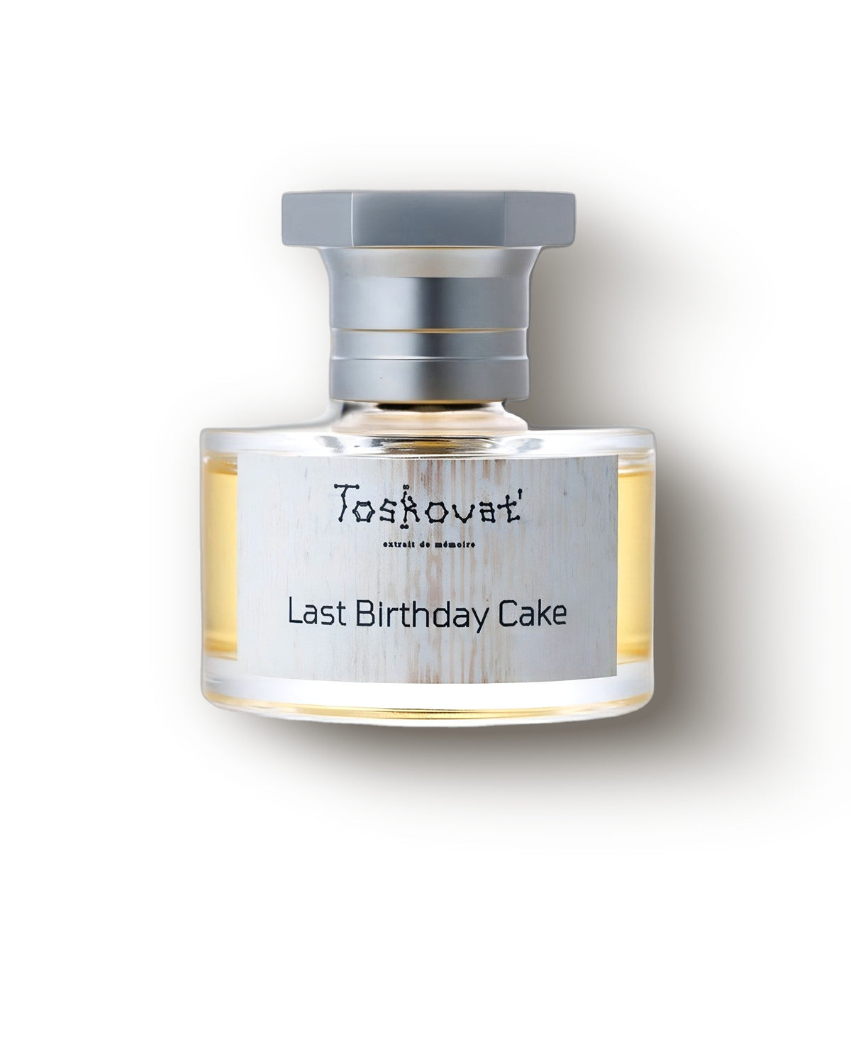 Flakon extrait Toskovat Last Birthday Cake ze szczotkowanym srebrnym wieczkiem na miękkim kremowym tle, decant niszowych perfum gourmand