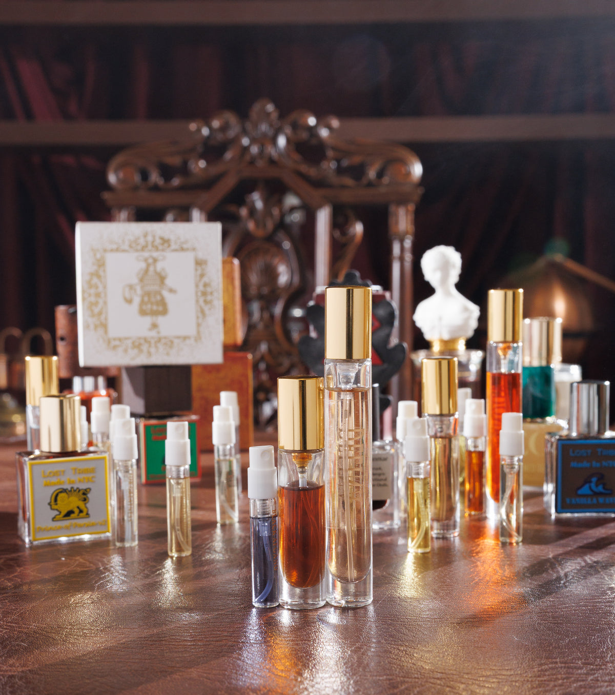 Gouttes Rares decants, a Black Afgano 2 ml, a 5 ml and a 10 ml, on a leather desk by a Lost Tribe Prince of Persia v2 bottle and a gold foil box, niche perfume decant